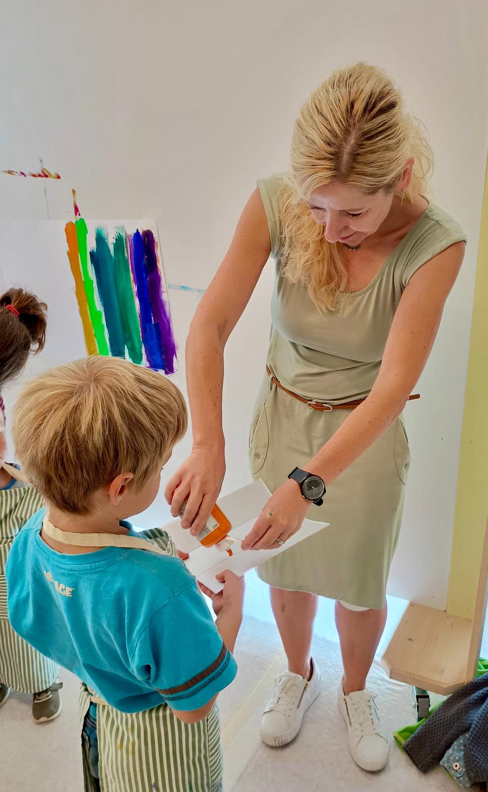Karin begleitet ein Kind beim Gestalten